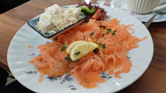 Lachs mit Zitrone und cremiger Beilage auf einem Blumenteller