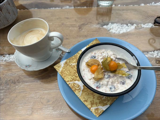 Müsli mit Physalis und eine Tasse Kaffee auf dem Holztisch