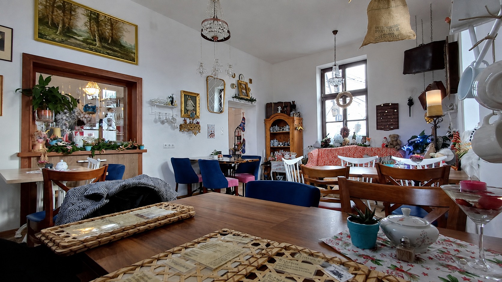 Blick in das Vintage Café mit gemütlichen Sitzplätzen, Holztischen und liebevoller Dekoration.